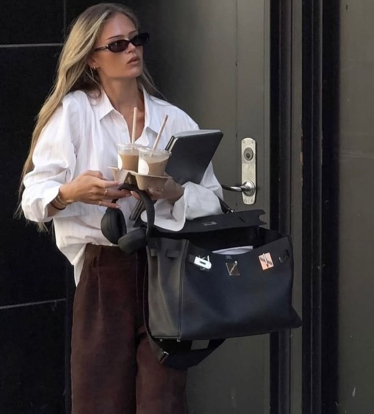 A woman leaving a building with her work bag, dressed with intention